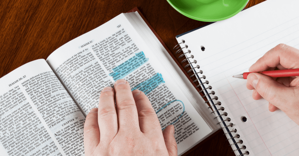 Woman writing highlighted text from the bible into a notebook.