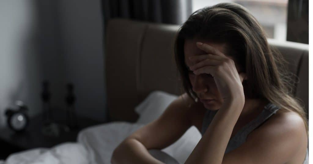Sad anxious woman with her hand over her face.