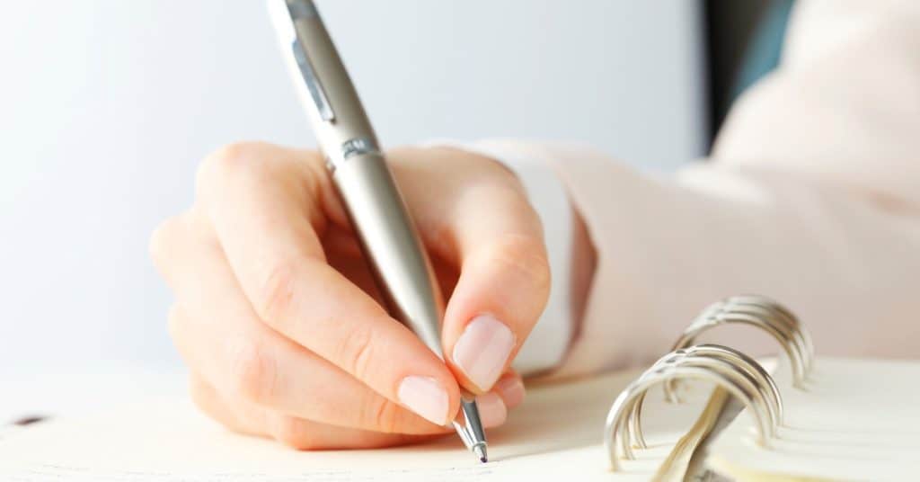 Woman's hand writing a list.