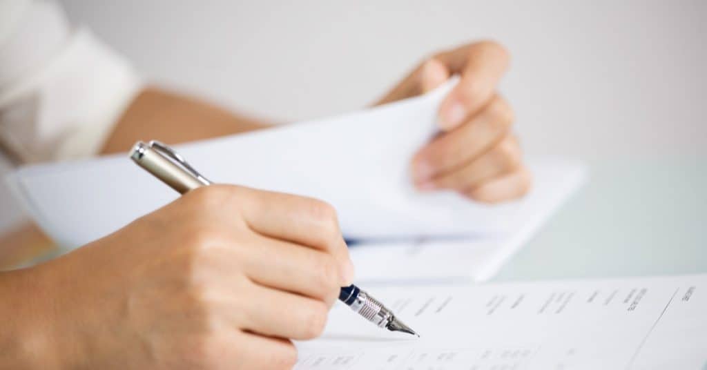 Woman's hand signing documents