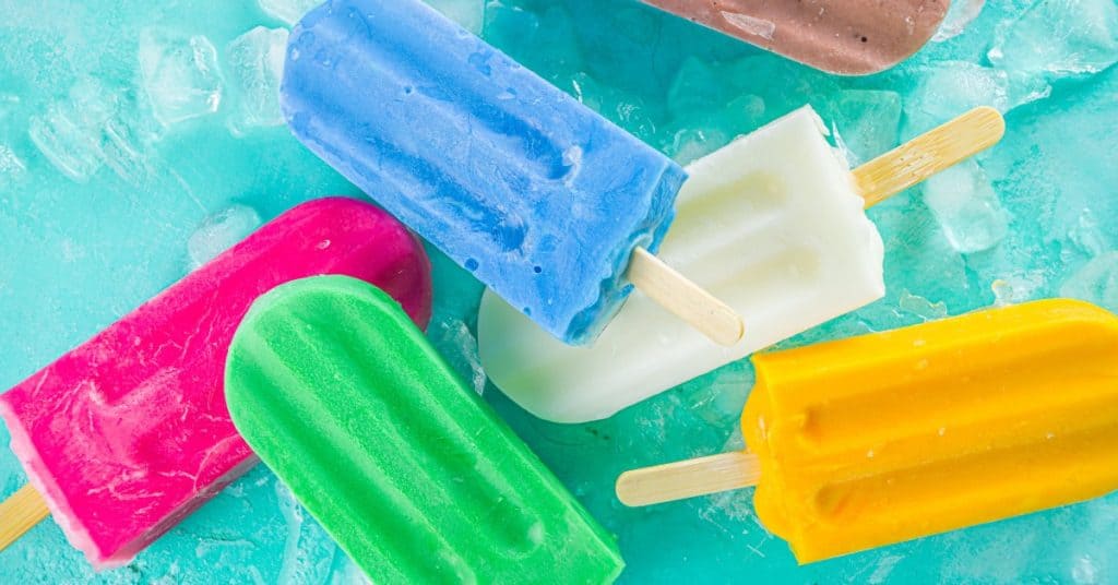 Bright colorful frozen popcicles on a blue background.